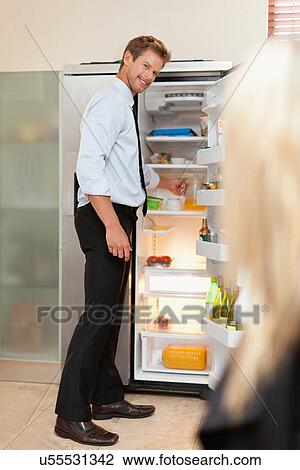 Stock Image - Man reaching into fridge. Fotosearch