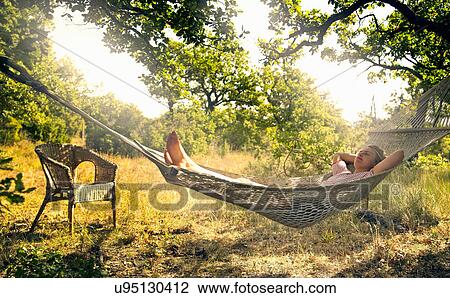 Man relaxing in hammock outdoors View Large Photo Image Stock Image - Man relaxing in hammock outdoors. Fotosearch