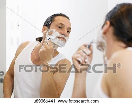 Man shaving his face in bathroom View Large Photo Image Stock Image - Man shaving his face in bathroom. Fotosearch