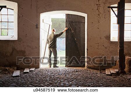Man standing at barn doors View Large Photo Image Stock Photo - Man standing at barn doors. Fotosearch