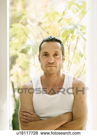 Stock Photo - Man standing with arms crossed. Fotosearch