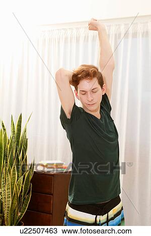 Man stretching in bedroom View Large Photo Image Stock Image - Man stretching in bedroom. Fotosearch