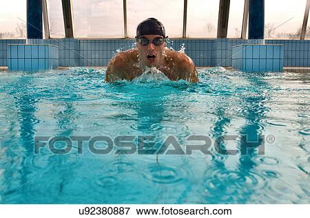 Stock Photo - Man swimming in indoor pool. Fotosearch