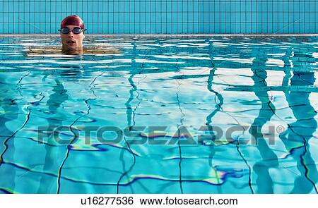 Stock Photograph - Man swimming in indoor pool. Fotosearch