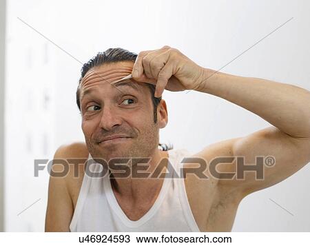 Man tweezing his eyebrows View Large Photo Image Stock Image - Man tweezing his eyebrows. Fotosearch