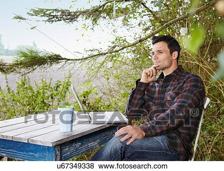 Man using laptop outdoors View Large Photo Image Stock Photo - Man using laptop outdoors. Fotosearch