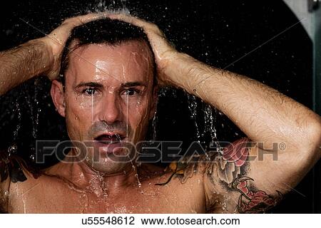 Stock Image - Man washing his hair in shower. Fotosearch