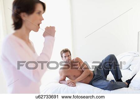 Man watching wife brush her teeth View Large Photo Image Stock Image - Man watching wife brush her teeth. Fotosearch