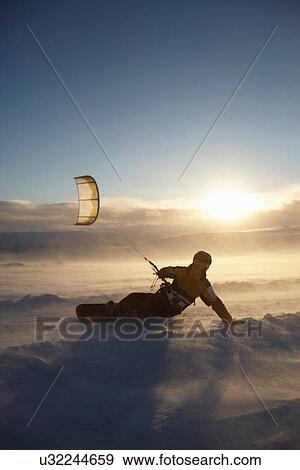 Man windsurfing on snowboard View Large Photo Image Stock Photo - Man windsurfing on snowboard. Fotosearch