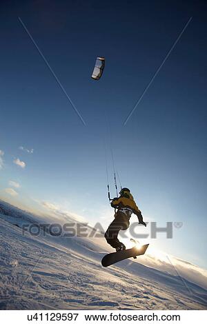 Stock Photo - Man windsurfing on snowboard. Fotosearch