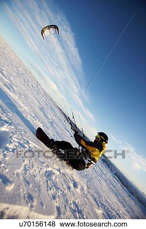 Stock Photo - Man windsurfing on snowboard. Fotosearch