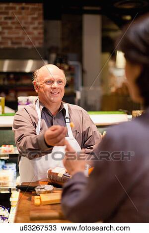 Stock Image - Man with free samples in grocery store. Fotosearch