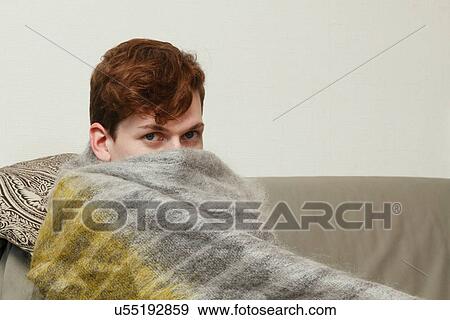 Man wrapped in blanket on couch View Large Photo Image Stock Photo - Man wrapped in blanket on couch. Fotosearch