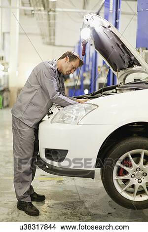Picture - Mechanic working on car engine. Fotosearch