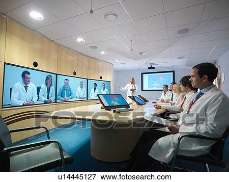 Medical professionals in meeting room taking part in video conference View Large Photo Image Stock Photo - Medical professionals in meeting room taking part in video conference. Fotosearch