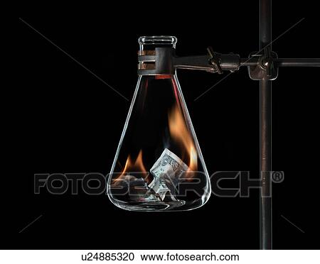 Stock Image - Money burning in beaker. Fotosearch