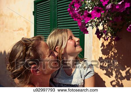 Stock Image - Mother and daughter admiring flowers. Fotosearch