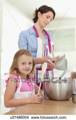 Picture - Mother and daughter baking in kitchen. Fotosearch
