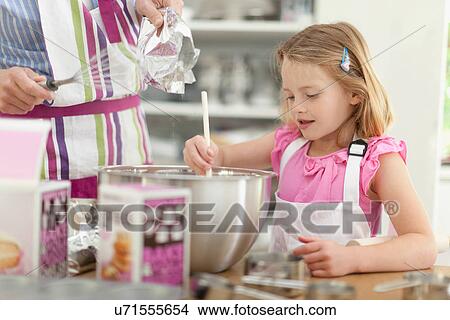 Picture - Mother and daughter baking in kitchen. Fotosearch