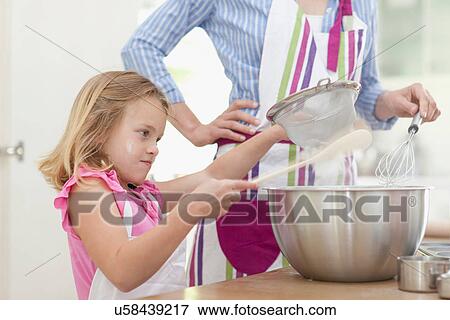 Stock Photo - Mother and daughter baking in kitchen. Fotosearch