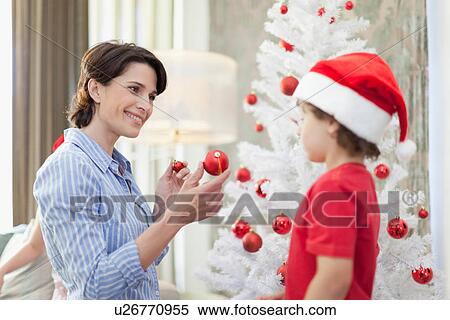Mother and son decorating Christmas tree View Large Photo Image Stock Photography - Mother and son decorating Christmas tree. Fotosearch