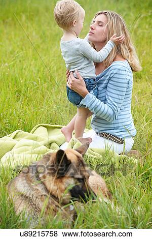 Mother and son sitting in grass with dog View Large Photo Image Stock Photo - Mother and son sitting in grass with dog. Fotosearch