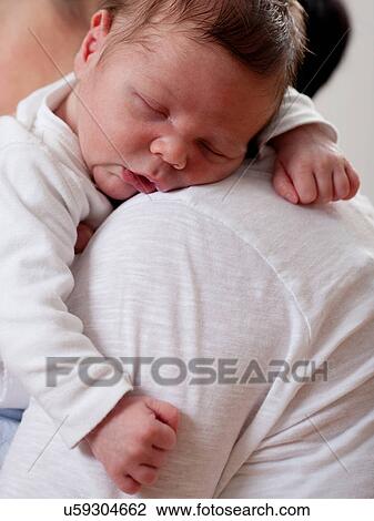 Stock Image - Mother carrying sleeping infant. Fotosearch