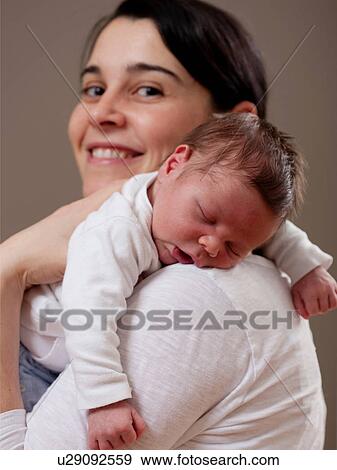 Mother carrying sleeping infant View Large Photo Image Stock Photo - Mother carrying sleeping infant. Fotosearch