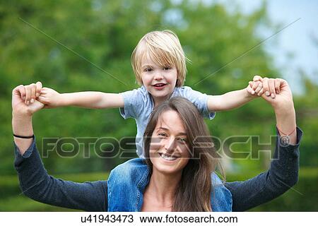 Mother carrying son on her shoulders View Large Photo Image Stock Image - Mother carrying son on her shoulders. Fotosearch