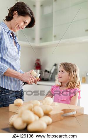 Mother helping daughter peel potatoes View Large Photo Image Stock Photograph - Mother helping daughter peel potatoes. Fotosearch