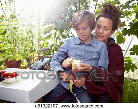 Mother peeling apple for son outdoors View Large Photo Image Stock Photo - Mother peeling apple for son outdoors. Fotosearch