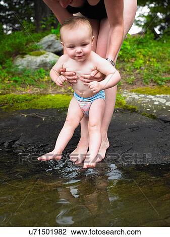 Mother playing with toddler in creek View Large Photo Image Stock Image - Mother playing with toddler in creek. Fotosearch