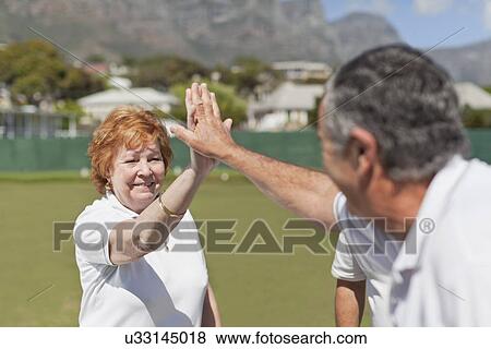 Older couple high fiving outdoors View Large Photo Image Stock Photo - Older couple high fiving outdoors. Fotosearch