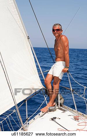 Stock Photo - Older man on railing of sailboat. Fotosearch