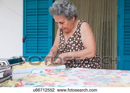 Older woman making pasta with roller View Large Photo Image Stock Image - Older woman making pasta with roller. Fotosearch