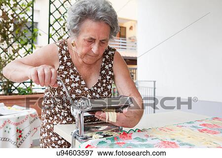 Older woman making pasta with roller View Large Photo Image Stock Photo - Older woman making pasta with roller. Fotosearch