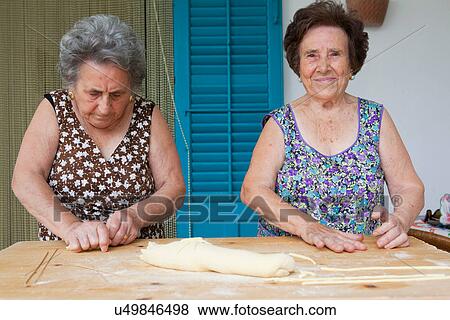 Older women making pasta together View Large Photo Image Stock Photo - Older women making pasta together. Fotosearch