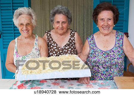 Stock Photo - Older women with basket of pasta. Fotosearch