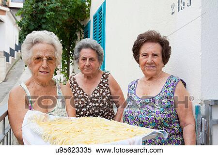 Stock Photography - Older women with basket of pasta. Fotosearch