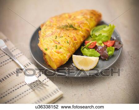 Stock Image - Omelet with Scottish smoked salmon, salad and lemon slice. Fotosearch