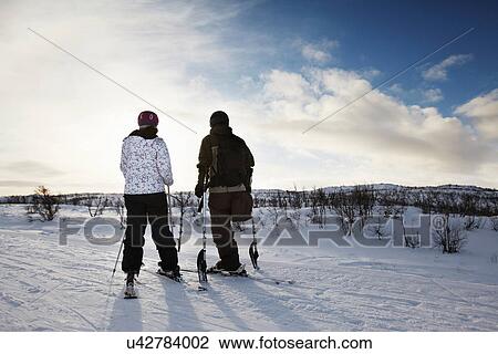 Stock Image - One-legged skier with girlfriend. Fotosearch