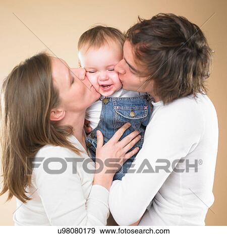 Stock Photo - Parents kissing smiling toddler. Fotosearch