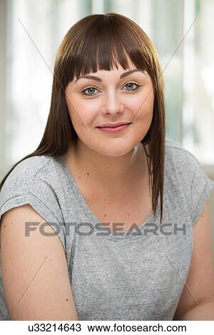 Portrait of a young woman, looking at camera View Large Photo Image Stock Image - Portrait of a young woman, looking at camera. Fotosearch