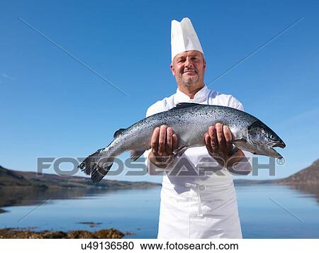 Portrait of chef holding freshly caught salmon by loch View Large Photo Image Stock Image - Portrait of chef holding freshly caught salmon by loch. Fotosearch