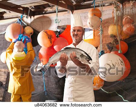 Portrait of chef holding freshly caught salmon in fisherman's hut View Large Photo Image Stock Image - Portrait of chef holding freshly caught salmon in fisherman's hut. Fotosearch