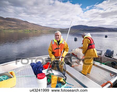 Portrait of fisherman with freshly caught salmon in net on loch of Scottish salmon farm View Large Photo Image Stock Photo - Portrait of fisherman with freshly caught salmon in net on loch of Scottish salmon farm. Fotosearch