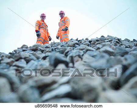Portrait of quarryman and assistant standing on stockpile of quarried stone View Large Photo Image Stock Photo - Portrait of quarryman and assistant standing on stockpile of quarried stone. Fotosearch