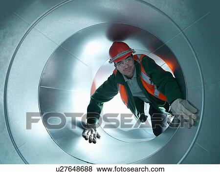 Portrait of workman in stainless steel air pipe of building site View Large Photo Image Stock Photo - Portrait of workman in stainless steel air pipe of building site. Fotosearch