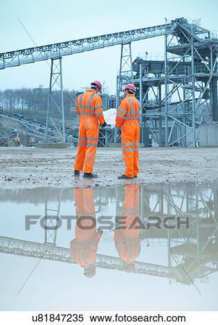 Quarryman and assistant looking at plans in front of quarry screening plant, rear view View Large Photo Image Stock Photography - Quarryman and assistant looking at plans in front of quarry screening plant, rear view. Fotosearch
