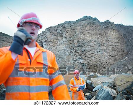 Quarryman using walkie talkie by cliff face of quarry View Large Photo Image Stock Photo - Quarryman using walkie talkie by cliff face of quarry. Fotosearch